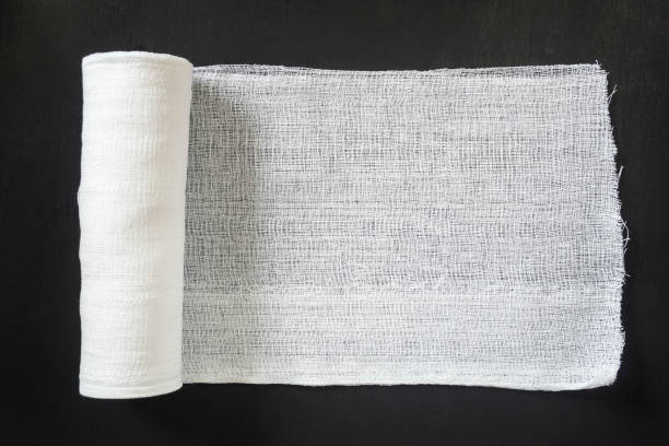 rolka białego bandaża medycznego na czarnym tle. - gauze bandage textured white zdjęcia i obrazy z banku zdjęć