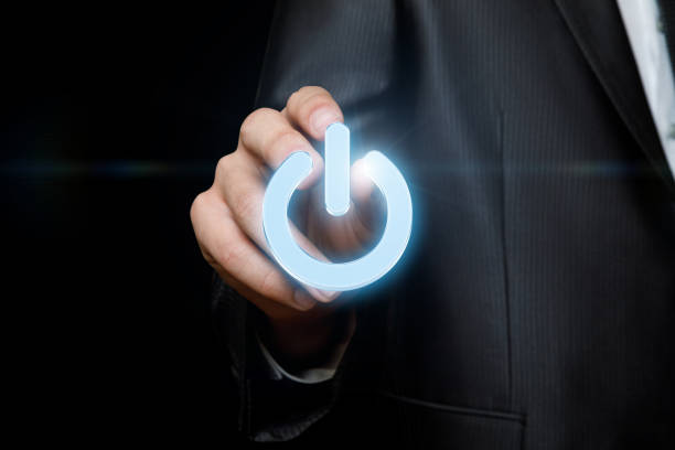 Businessman touches of the button power on the dark background.