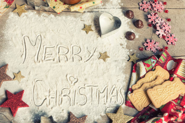 istock Merry Christmas, text made with flour, surrounded by Christmas decorations. 1037026048