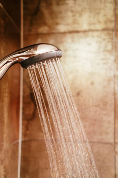 istock Shower head and running water in bath 1037027030