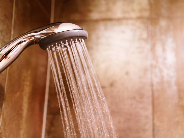 istock Shower head with running water in bath 1037027072