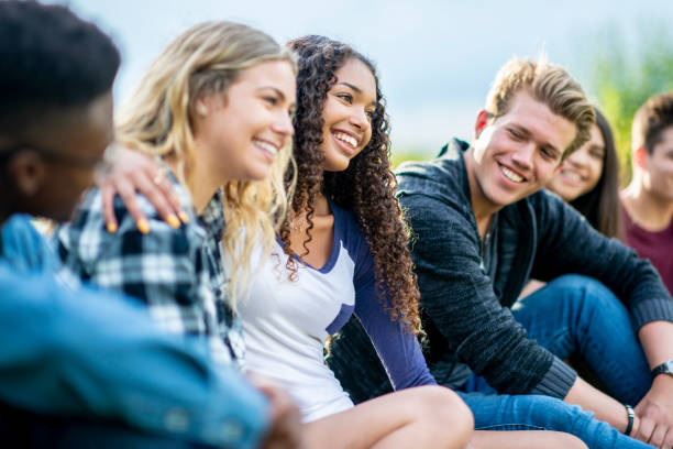 istock Diverse group of teens sitting together on the lawn 1037044244