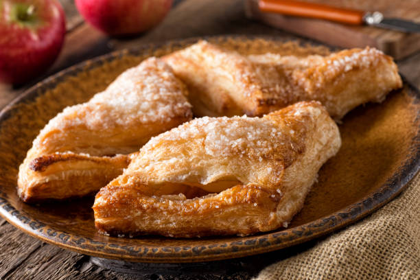 Apple Turnovers Delicious freshly baked homemade apple turnovers with coarse sugar topping. strudel stock pictures, royalty-free photos & images