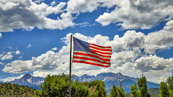 American Flag Flying with Beautiful Sky and San Juan Mountains, CO in Background