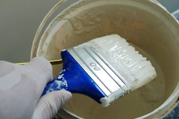 istock white paint bucket and brush paint roll beside, 1037059326