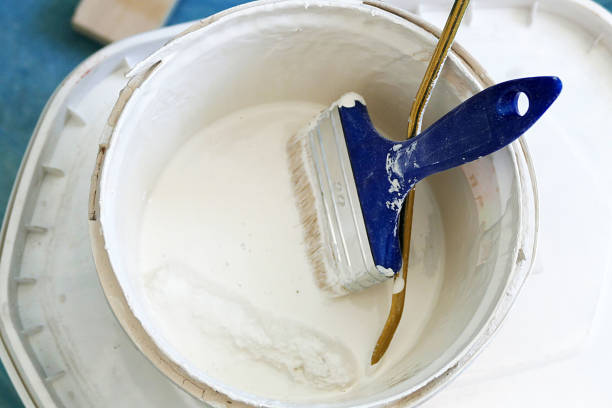 istock white paint bucket and brush paint roll beside, 1037059474