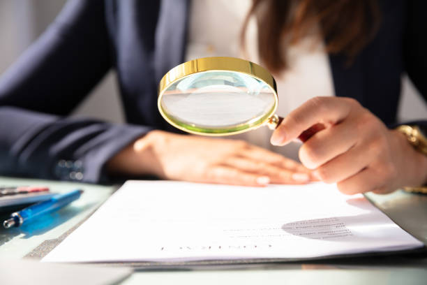 Businesswoman Looking At Contract Form Through Magnifying Glass Close-up Of A Businesswoman's Hand Looking At Contract Form Through Magnifying Glass magnifying glass photos stock pictures, royalty-free photos & images