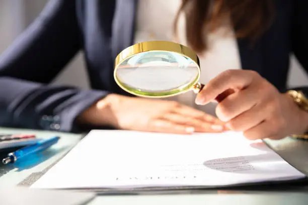 Photo of Businesswoman Looking At Contract Form Through Magnifying Glass