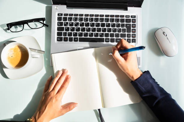 istock Close-up Of A Businesswoman's Hand Writing Note In Diary 1037076864