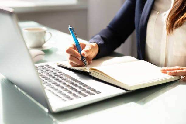 istock Close-up Of A Businesswoman's Hand Writing Note In Diary 1037077000