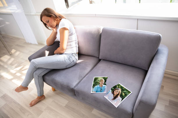 lonely woman sitting on sofa - former imagens e fotografias de stock