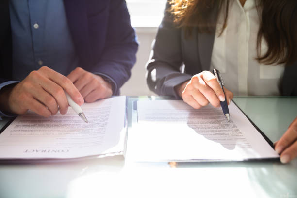 istock Two Businesspeople Working On Contract Paper 1037082128
