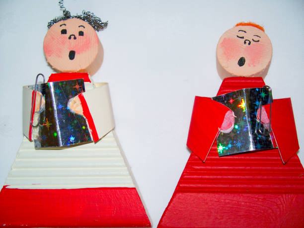 istock Wooden Caroler Boys Figurine Holding Hymn Book 1037082838
