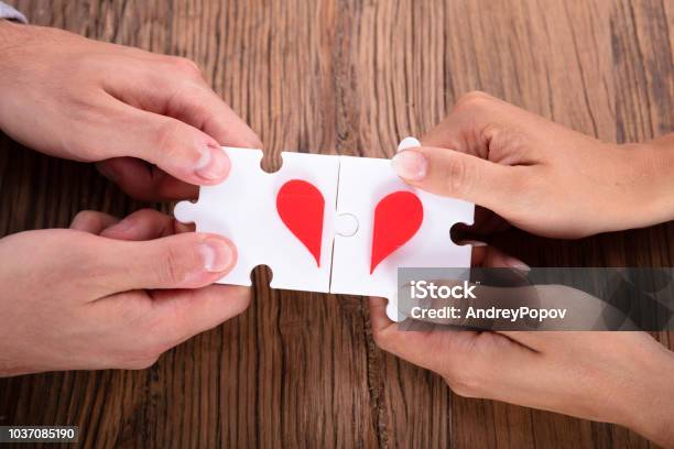 Couple Connecting Red Heart Puzzle Together Stock Photo - Download Image Now - Above, Adult, Adults Only