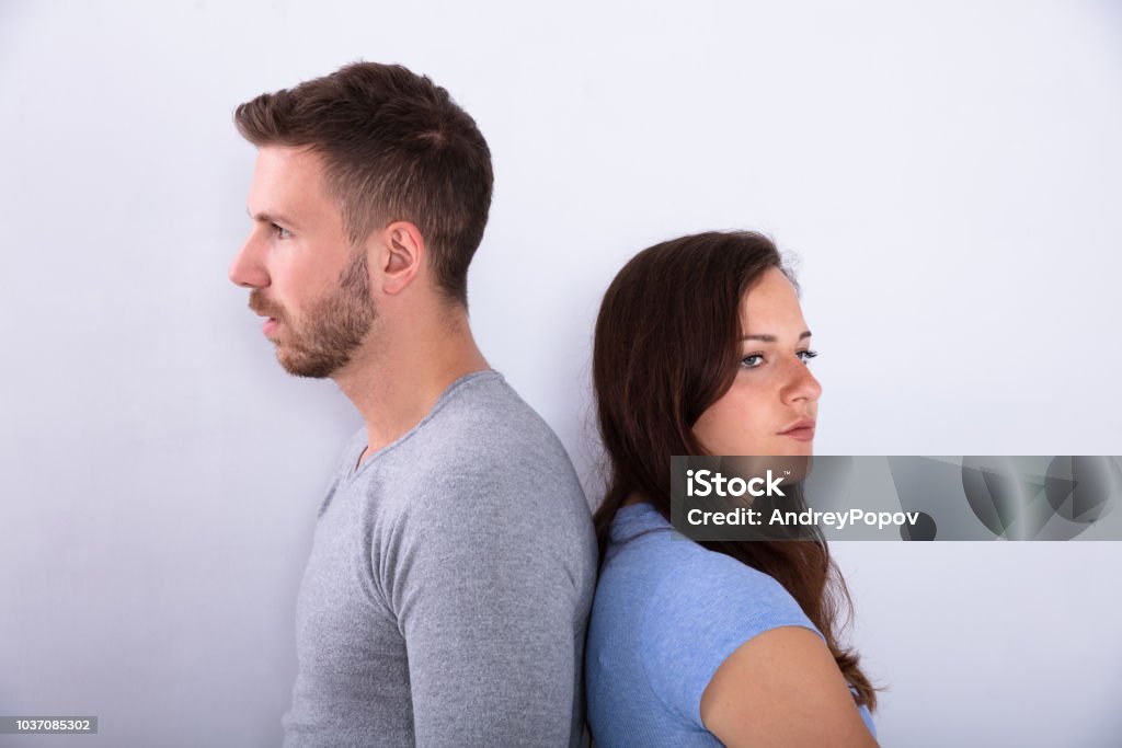 Unhappy Couple Standing Back To Back Unhappy Couple Standing Back To Back On Grey Background Adult Stock Photo