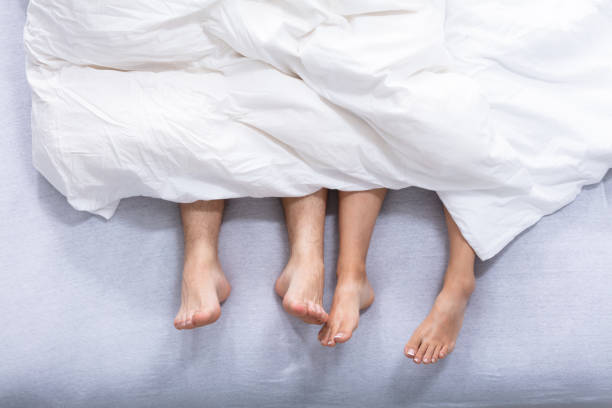 istock Feet Of Couple On Bed 1037085450