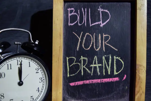 Photo of Build your brand on phrase colorful handwritten on blackboard.