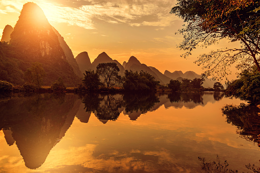 Aerial view of Shangri-la Gardens at sunset, boats in the river, rice fields and karst mountains in the background, Yangshuo, Guilin, Guangxi Province, China
