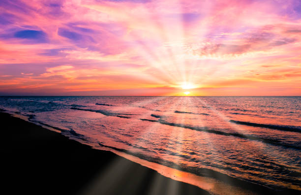 Scenic view of the sea with sun rays piercing through clouds