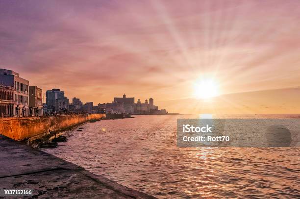 Sunset Over Malecon And Atlantic Ocean With Residential Building And Visible Sun Rays Havana Cuba Stock Photo - Download Image Now