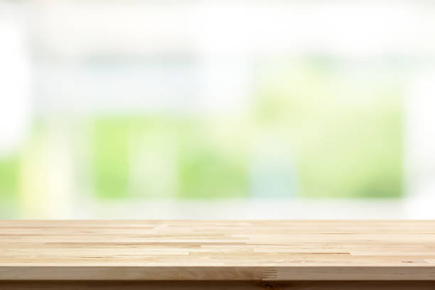 istock Wood table top on blur white green kitchen window background 1037155652