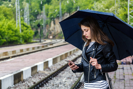 Beautiful Girl  using her phone on the railway station