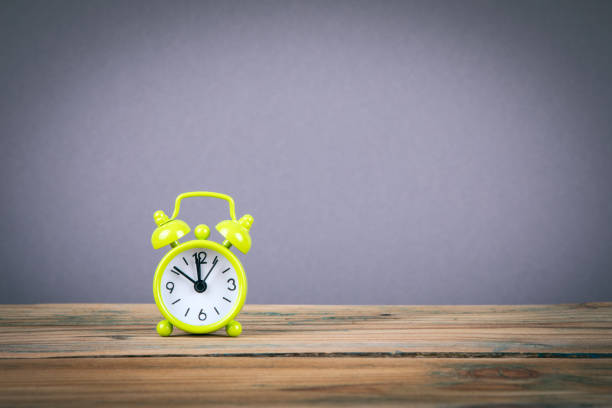 istock Green Alarm Clock on wooden table 1037163594