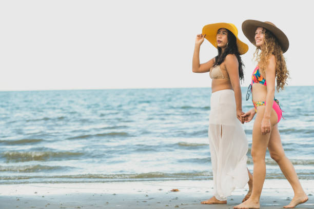 istock Happy women go sunbathing at sand beach in summer. 1037179480