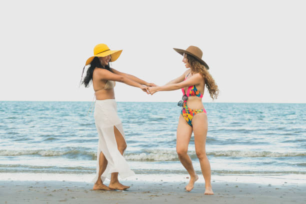 istock Happy women dance on sand beach in summer. 1037179530