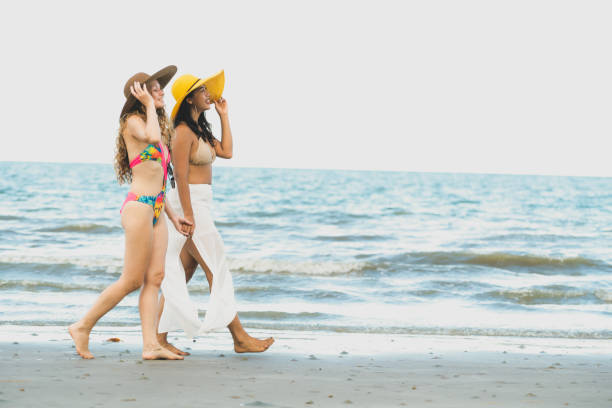 istock Happy women go sunbathing at sand beach in summer. 1037179558