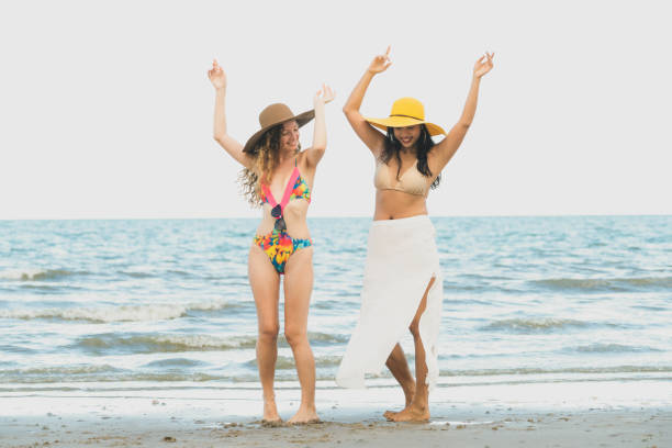 istock Happy women dance on sand beach in summer. 1037179584