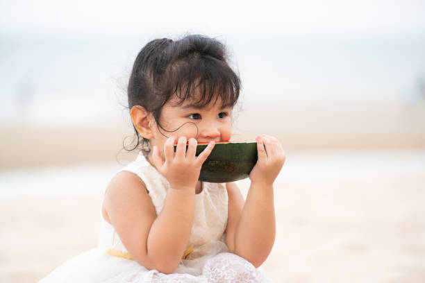 istock Adorable kid eating watermelon on the beach. 1037180334