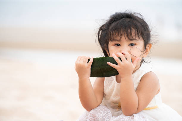istock Adorable kid eating watermelon on the beach. 1037180392