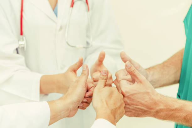 istock Doctor, surgeon and nurse join hands together. 1037184834