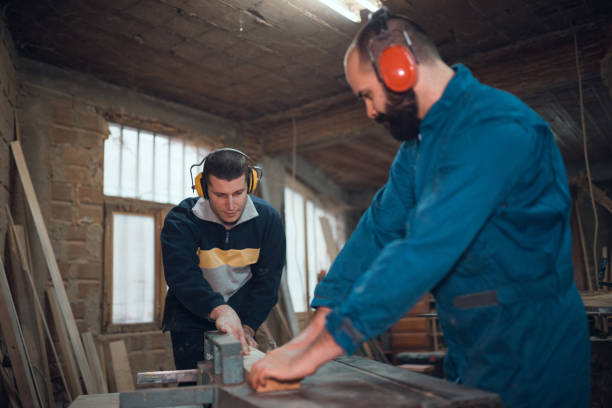 istock Two men working in the carpenter's workshop and processing wood 1037192988