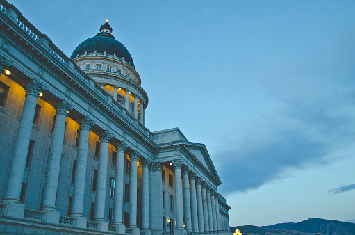 A grand view of the utah state capitol in the evening setting sunlight under the clouds.