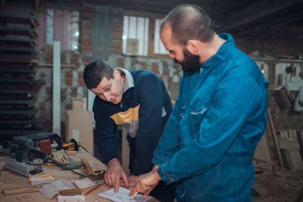 istock Two people working in the carpenters workshop and making wooden objects 1037220144