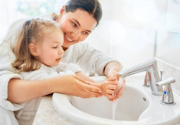 girl and her mother are washing hands Cute little girl and her mother are washing hands under running water. grooming product photos stock pictures, royalty-free photos & images