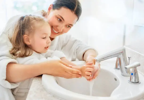 Photo of girl and her mother are washing hands
