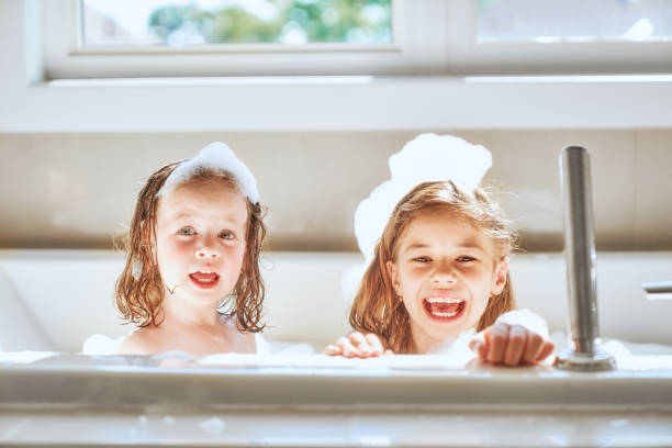 children are bathing in a bath Happy children girls are bathing in a bath with foam and bubbles. girls bath stock pictures, royalty-free photos & images