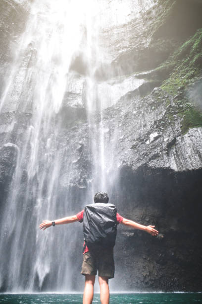 istock Travel Man Adventure and standing relaxation at Madakaripura waterfall East Java,IndonesiaIndonesia 1037264774