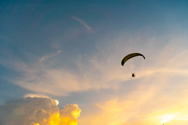 istock Man is riding para motor in beautiful  sunset cloud sky background. 1037278372