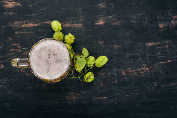 istock Beer in a glass mug. On a black wooden table. Free space for text. Top view. 1037290784