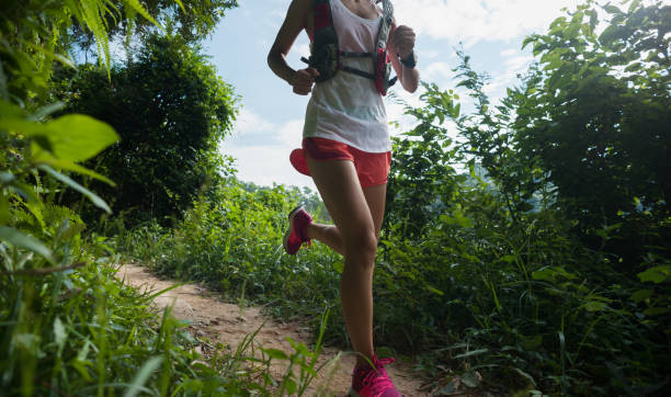 istock Young woman trail runner running on tropical forest trail 1037291642