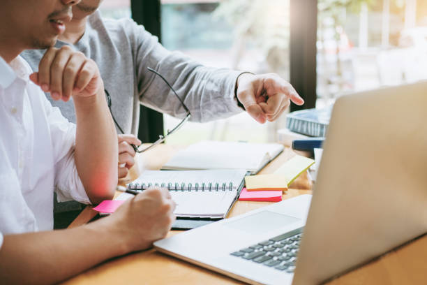istock University students using laptop meeting for research homework in college 1037296028
