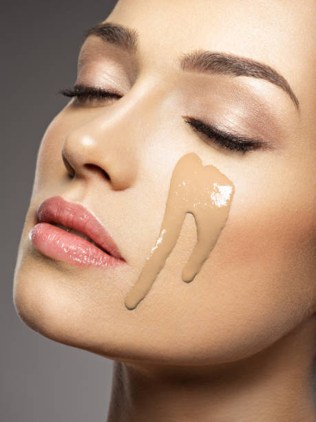 istock liquid cosmetic makeup foundation is on the female face 1037300026