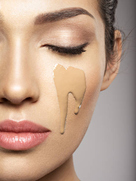 istock liquid cosmetic makeup foundation is on the female face 1037300048