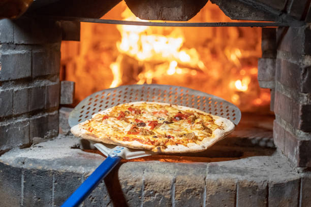 istock Baking Pizza in a Wood fire Brick oven 1037305060
