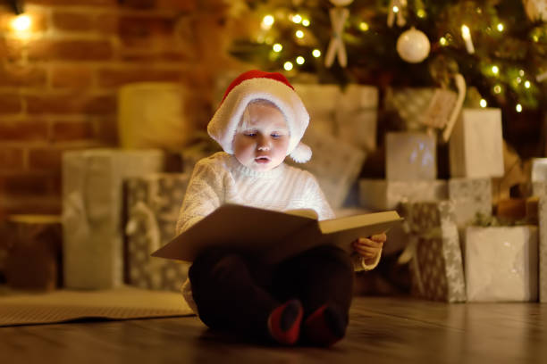 istock Little boy reading a magic book in decorated cozy living room 1037308302