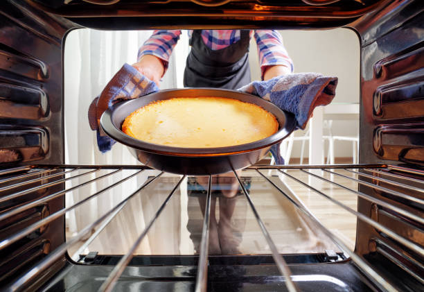 istock Housewife using dishcloth for taking cheesecake out of oven 1037324632